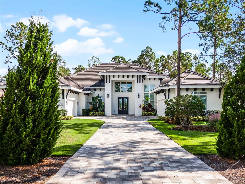 a front view of a house with a yard and trees