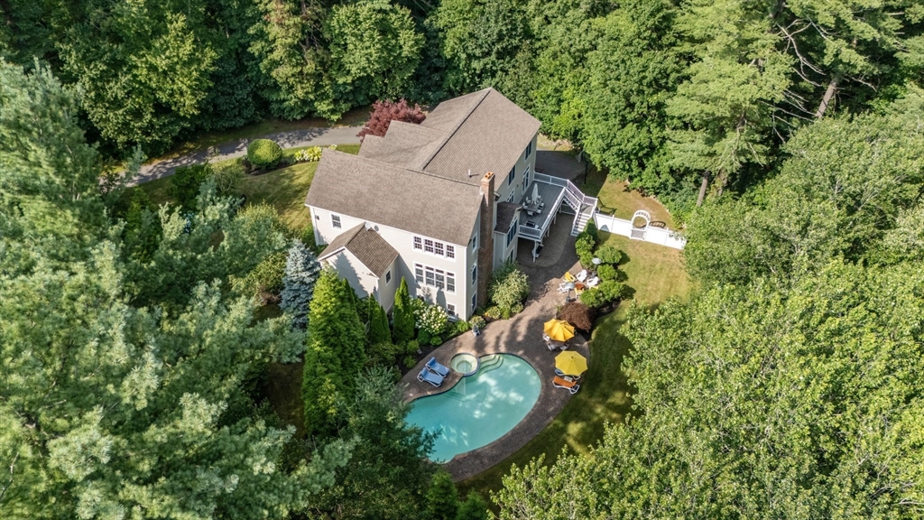 an aerial view of a house with a yard and large trees