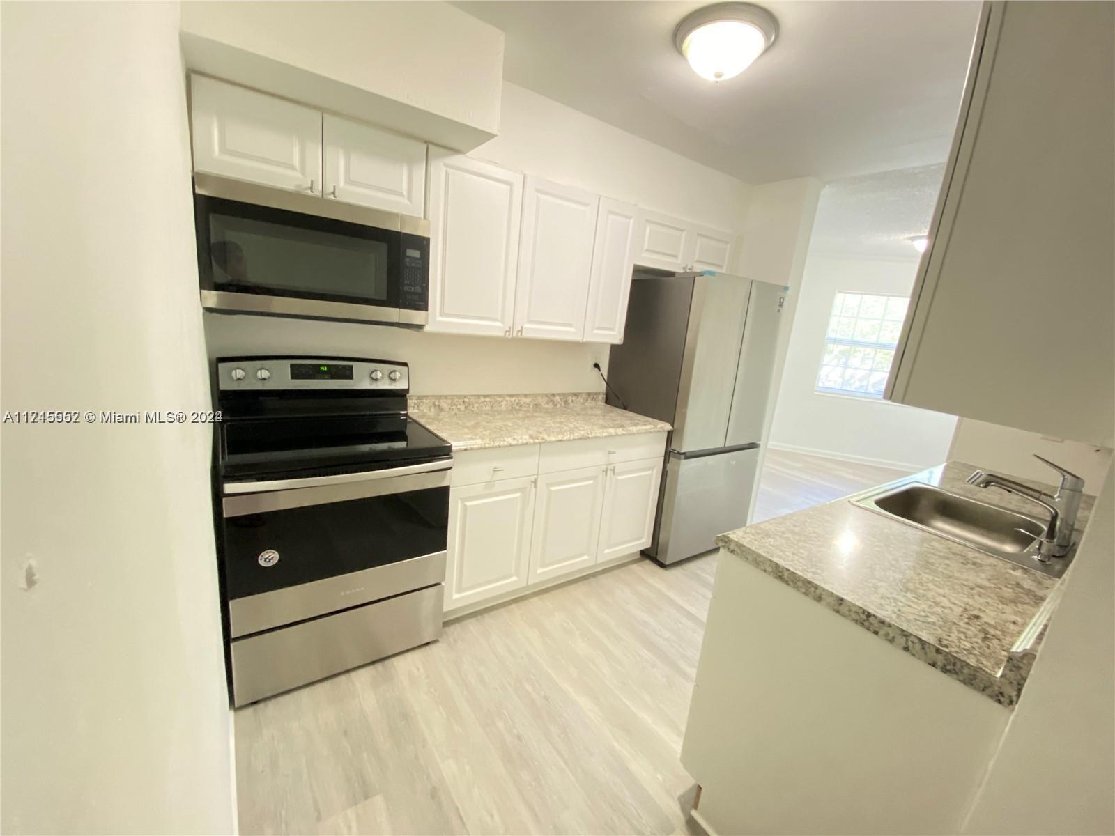 a kitchen with stainless steel appliances granite countertop a stove microwave and sink