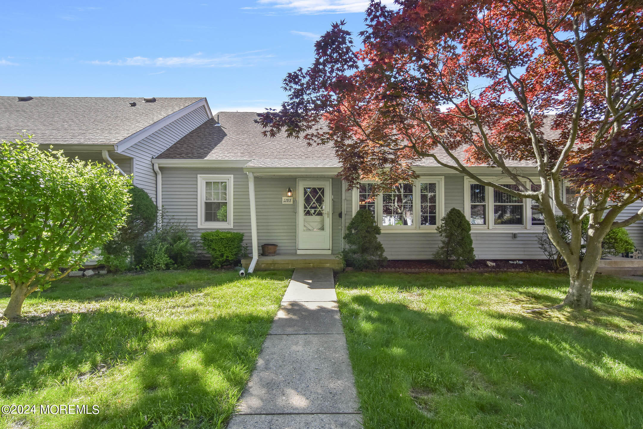 a front view of a house with a garden and yard