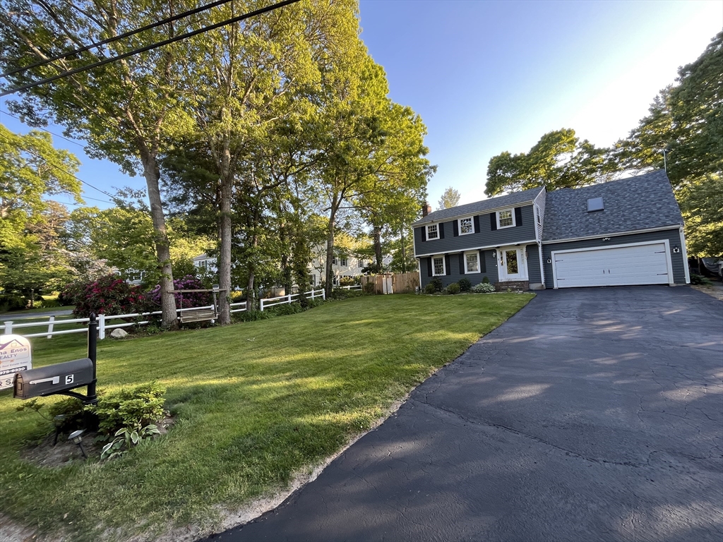 a view of a house with a big yard and large trees