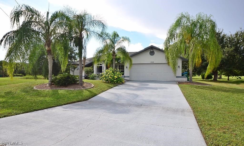 a front view of a house with a yard and trees