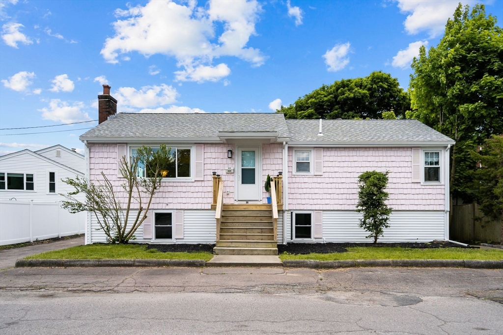 a front view of a house with a yard and potted plants