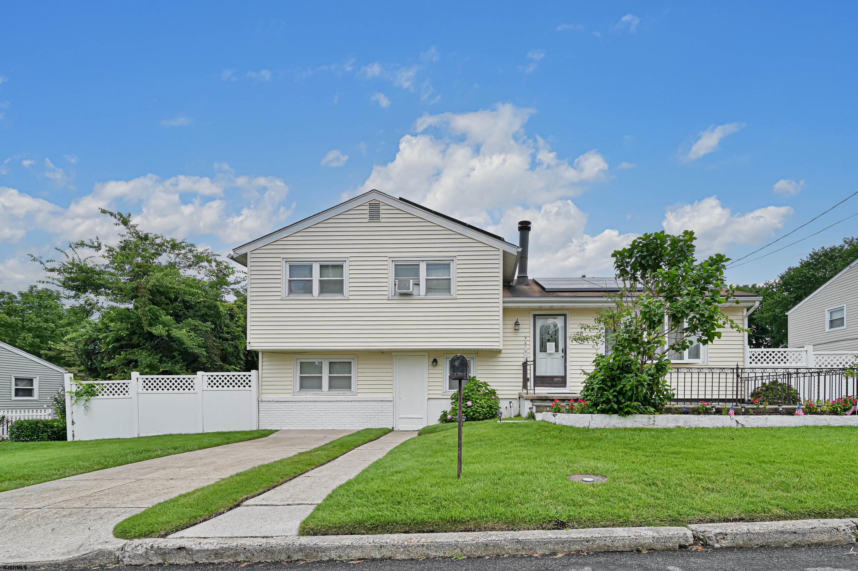 a front view of a house with a garden and yard