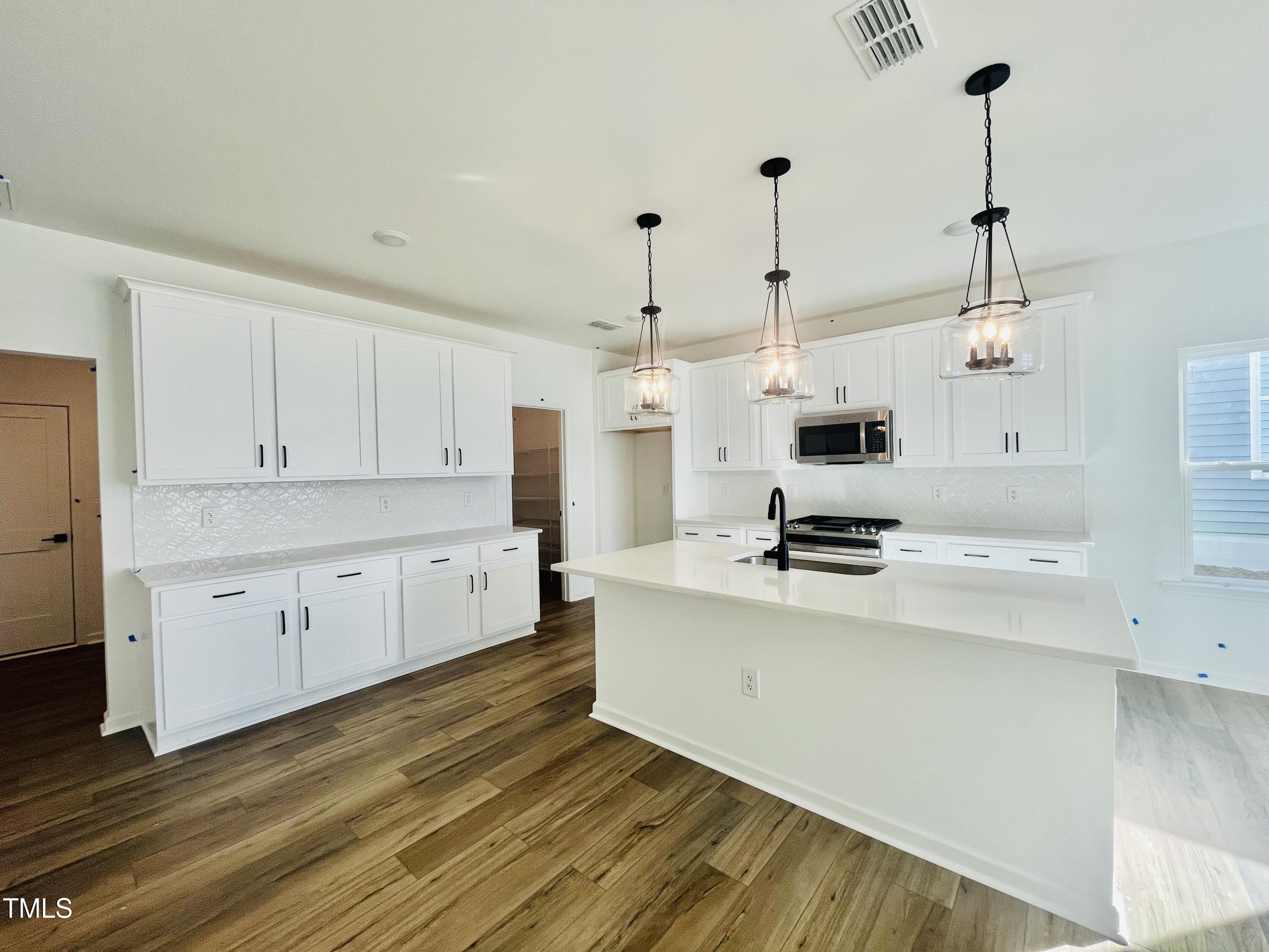 a kitchen with stainless steel appliances kitchen island sink stove and cabinets