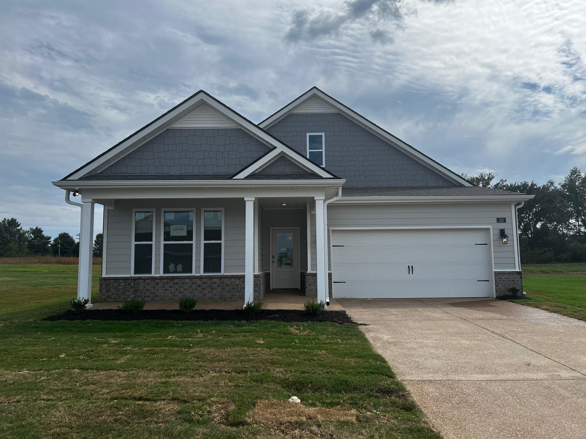 Craftsman house with a porch, a garage, and a front yard