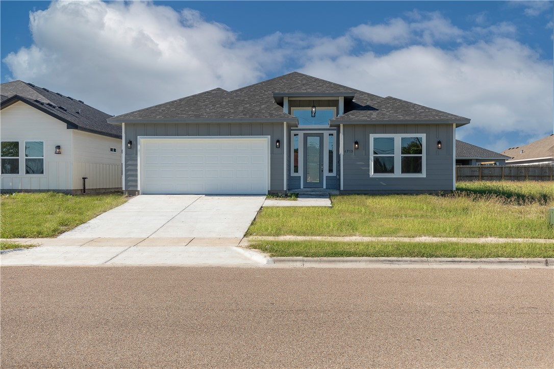 a front view of house with yard and garage