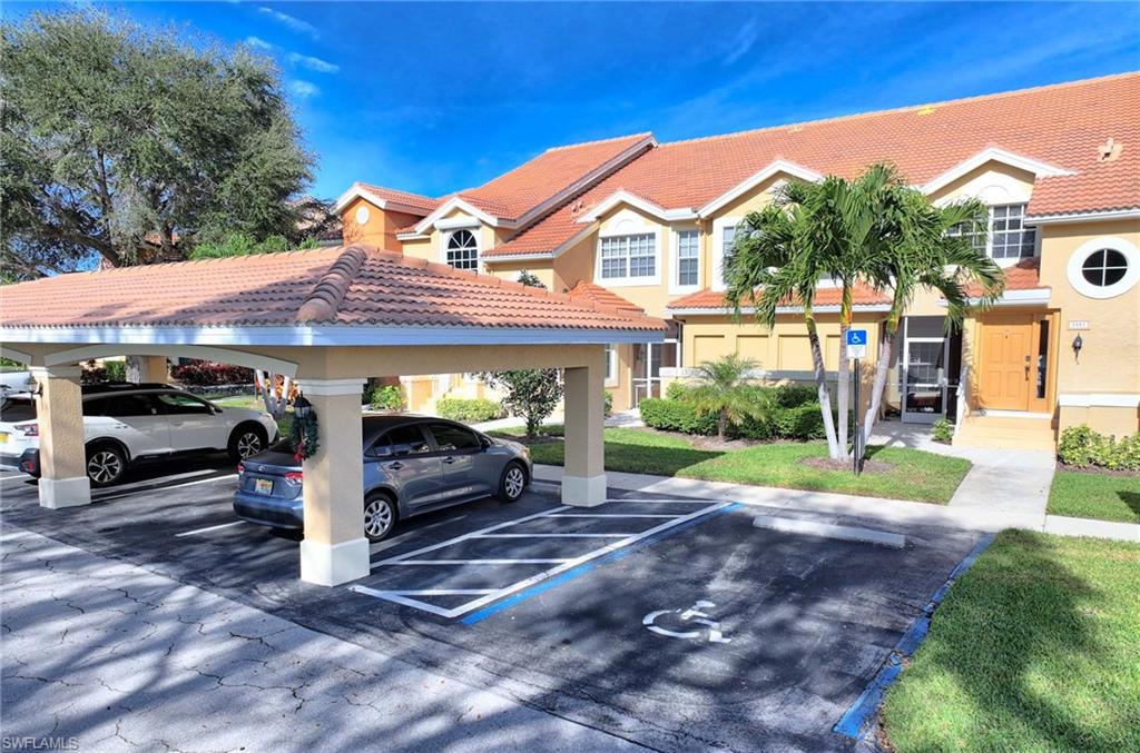 View of car parking with a yard and a carport