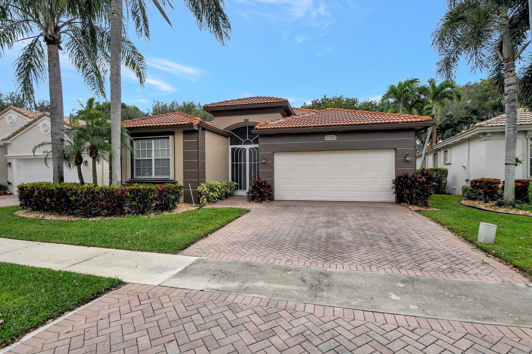 a front view of a house with a yard and a garage