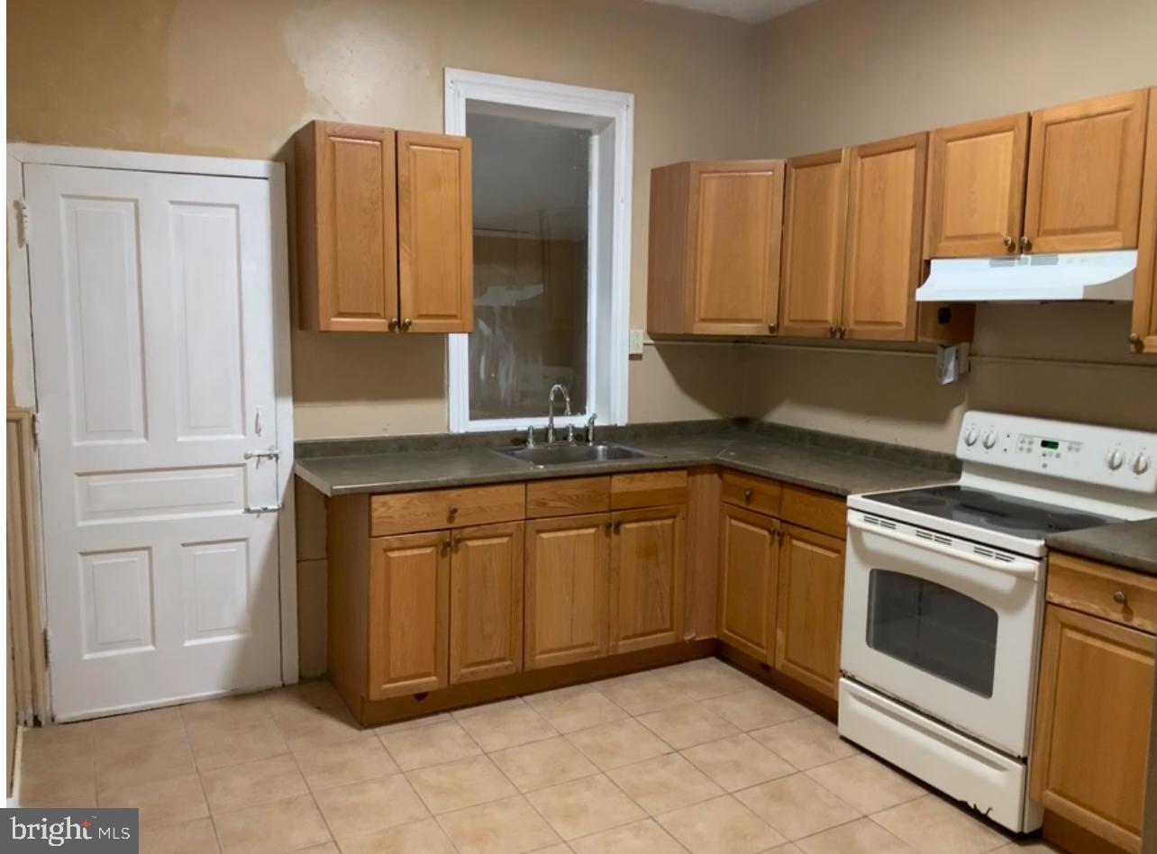 a kitchen with granite countertop a sink and a stove