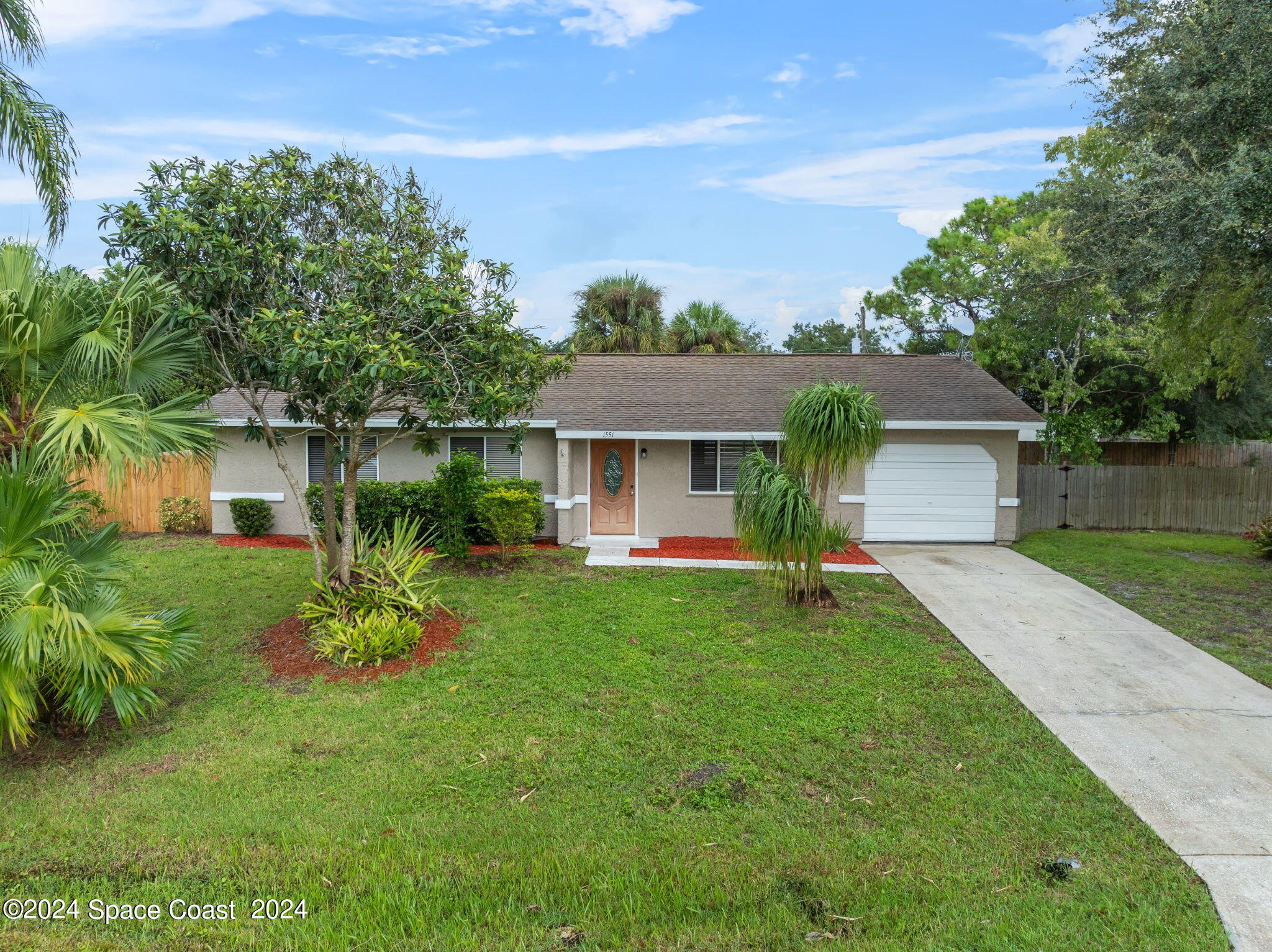 a front view of a house with a yard and a garage