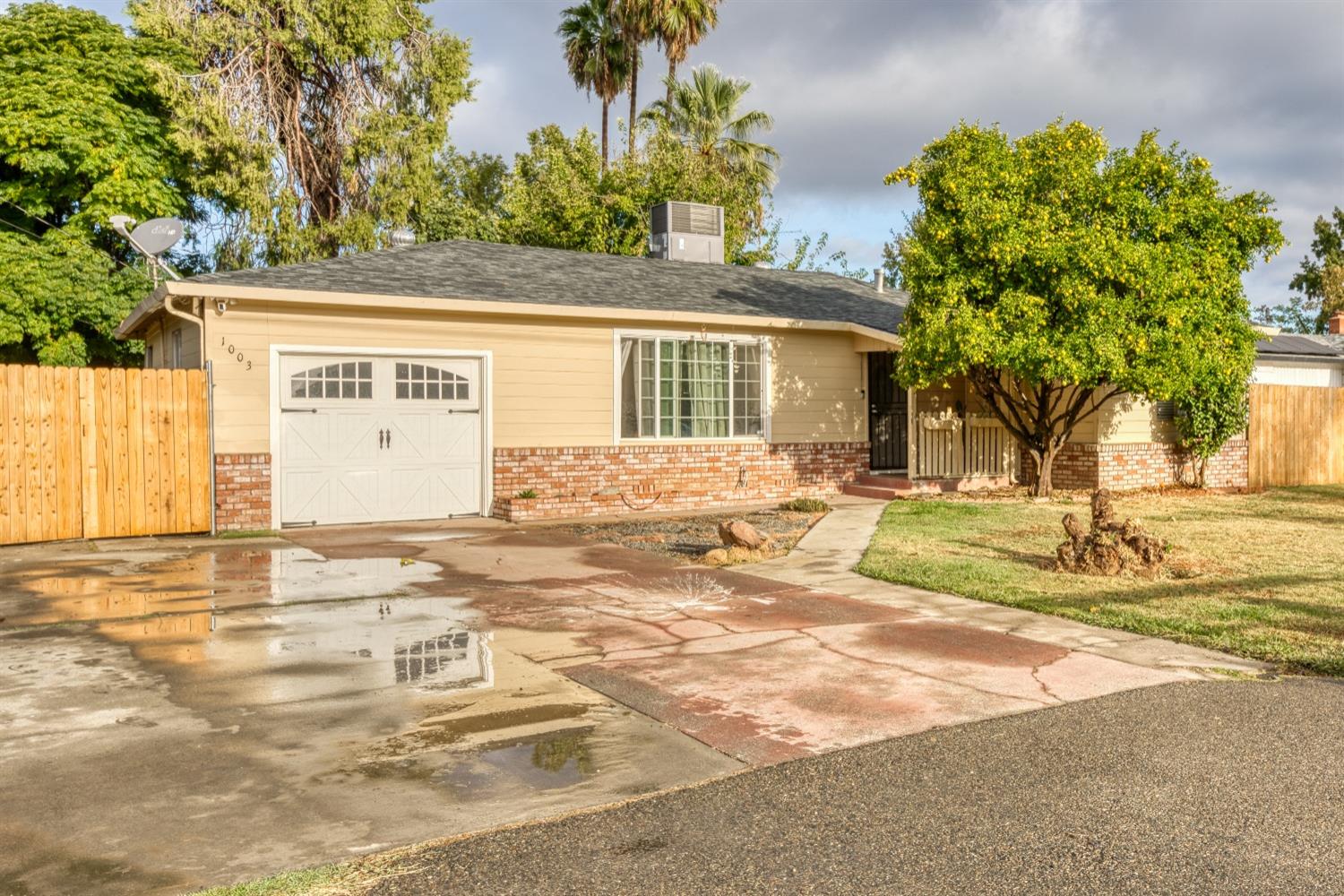 a view of a house with a yard and palm trees