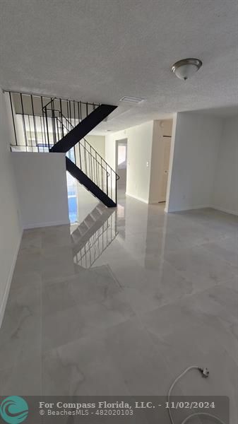 a view of staircase with lots of frames on wall and a ceiling fan