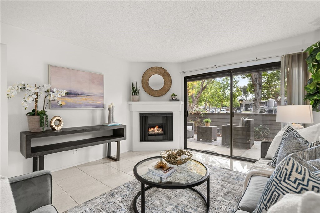 a living room with furniture a fireplace and a large window