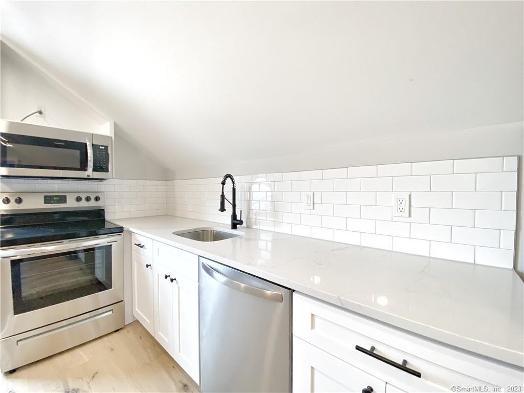 a kitchen with a sink cabinets and stainless steel appliances