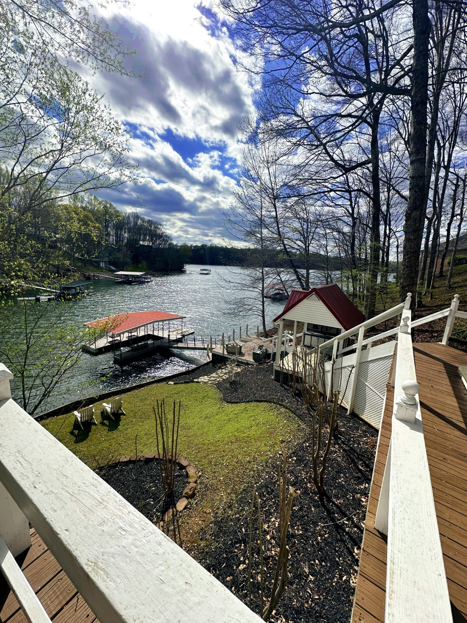 a view of a wooden deck and lake with trees in the background