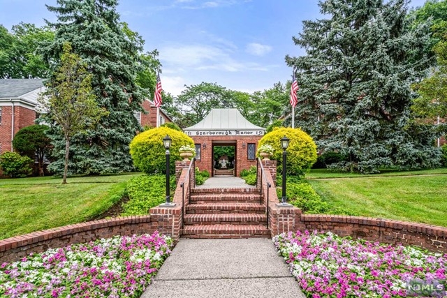 a front view of a house with a yard and fountain in middle