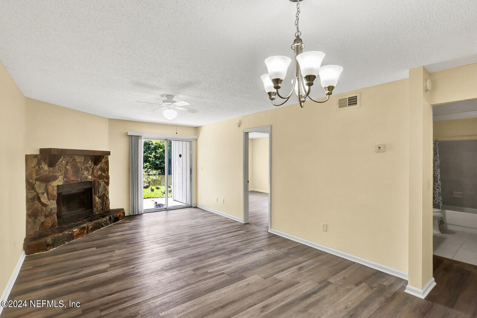 a view of a livingroom with wooden floor a fireplace and window