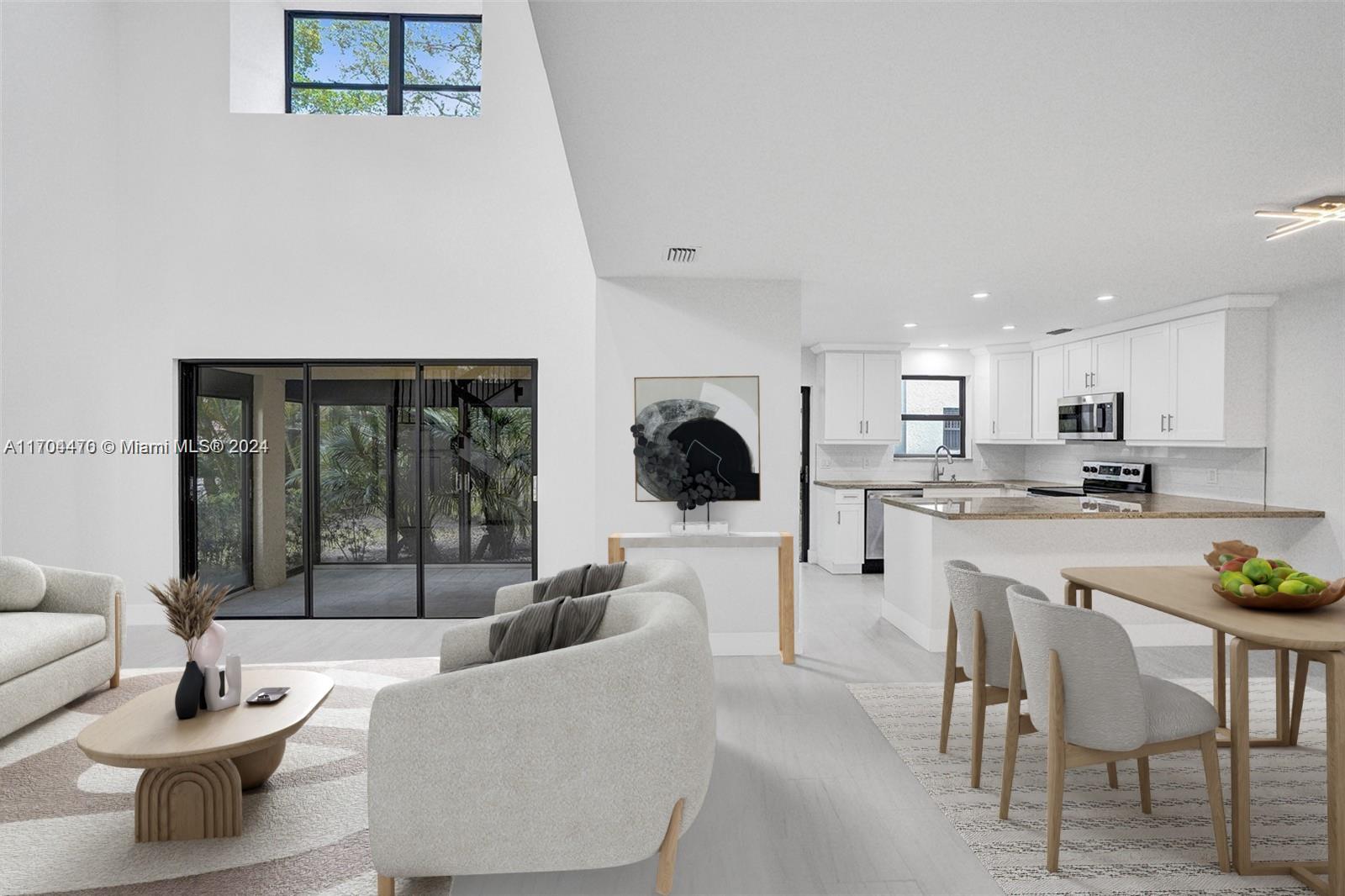 a living room with stainless steel appliances kitchen island granite countertop furniture and a large window