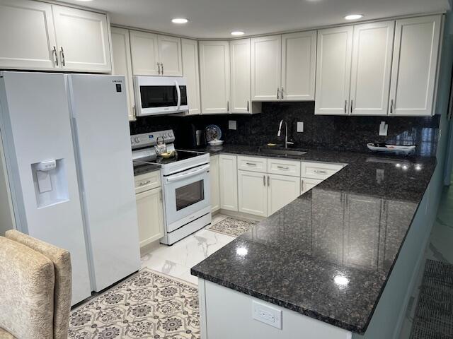 a kitchen with stainless steel appliances granite countertop a sink a stove a microwave and cabinets