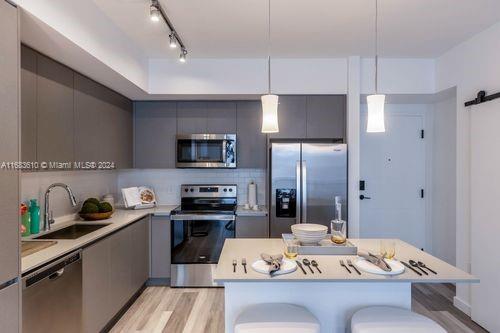 a kitchen with a refrigerator and a stove top oven