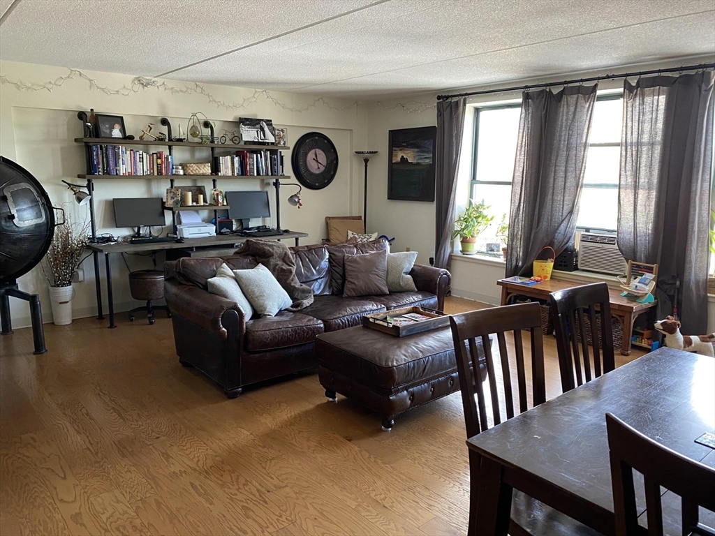 a living room with furniture kitchen view and a window