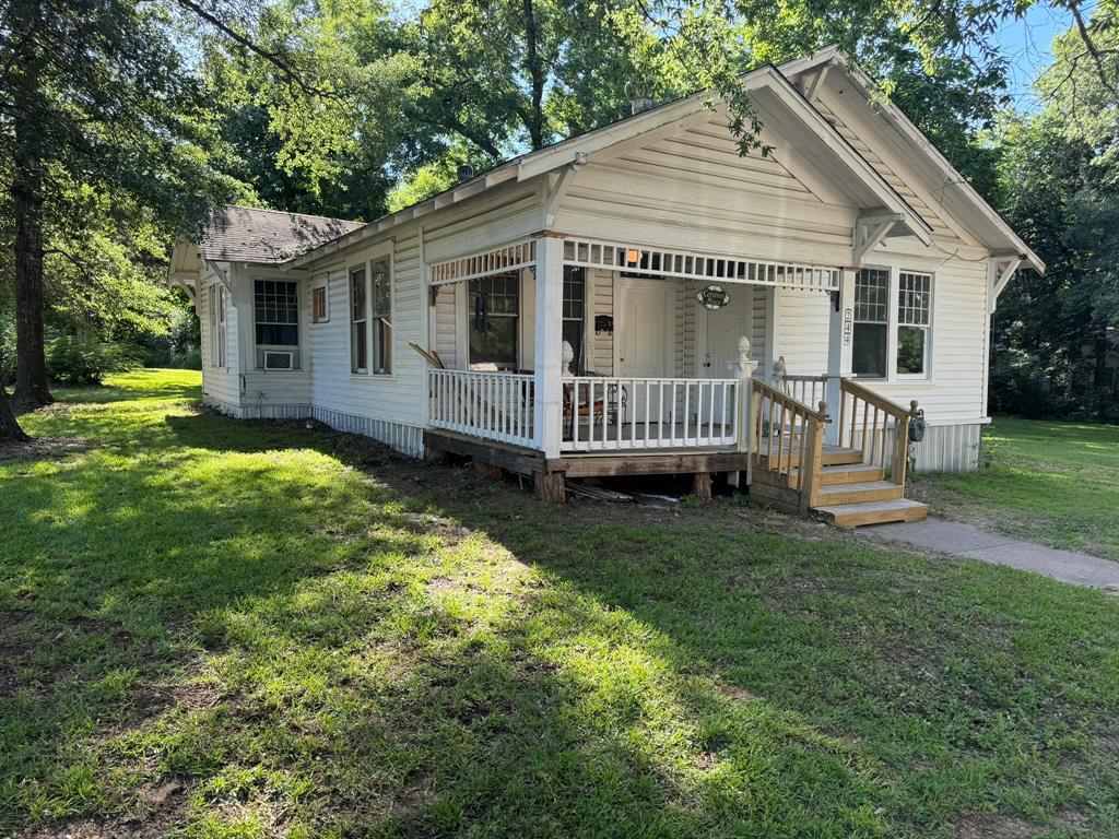 a view of a house with a yard and deck