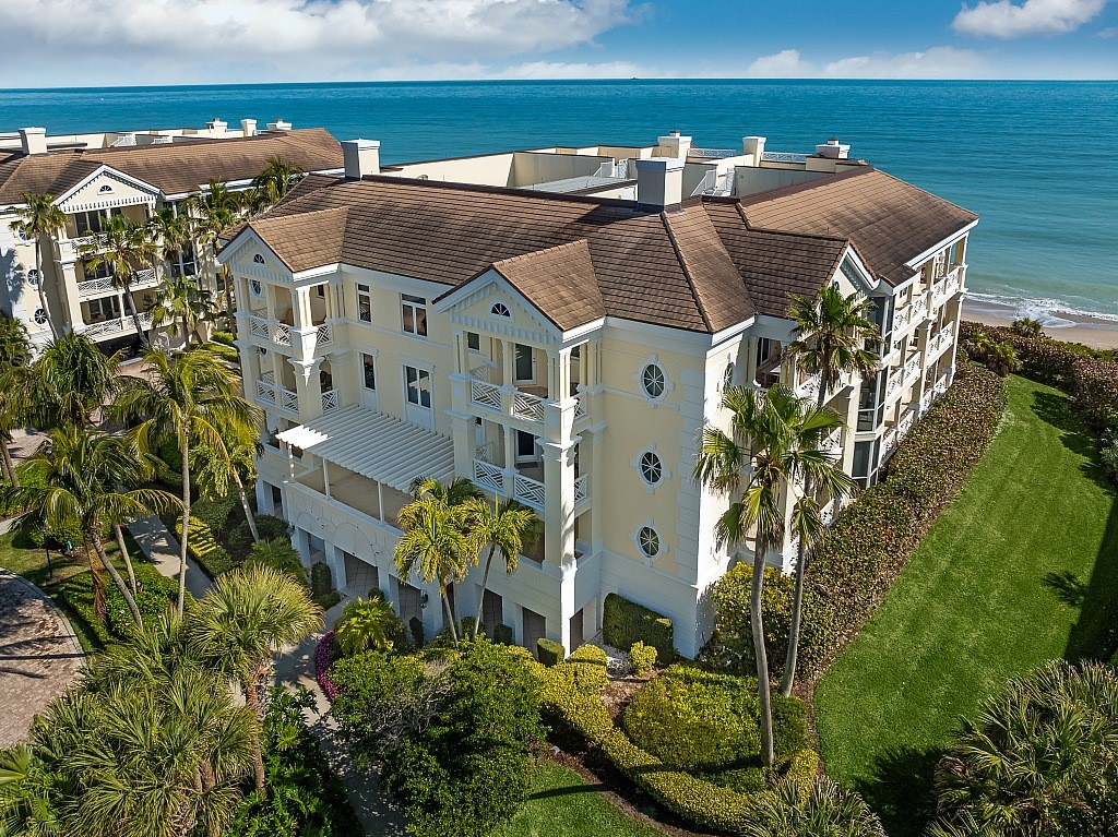 an aerial view of multiple houses with a yard