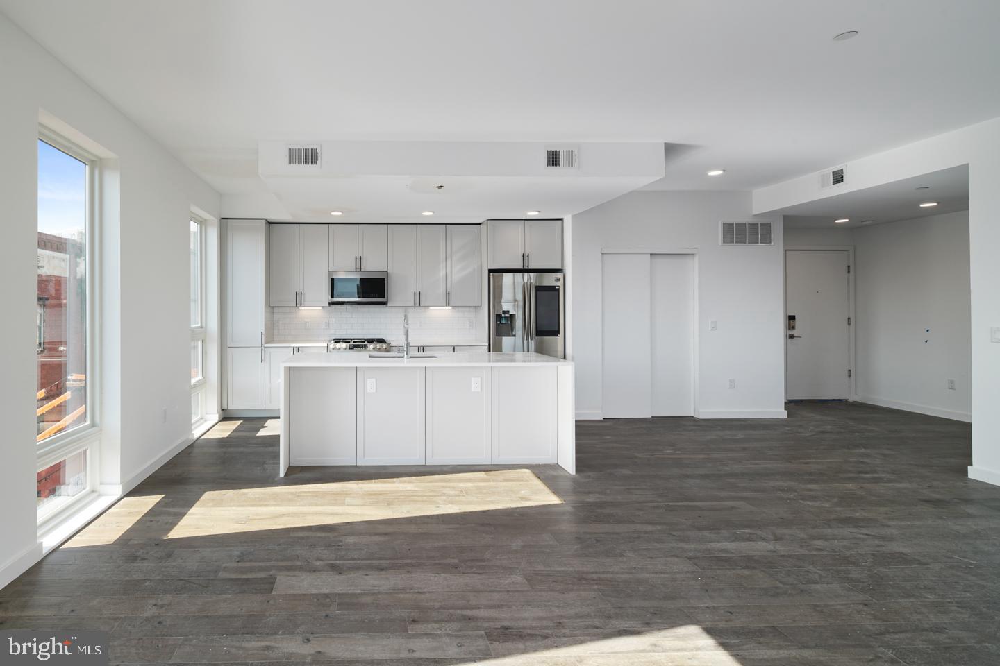 a view of kitchen with kitchen island a sink dishwasher stove with wooden floors