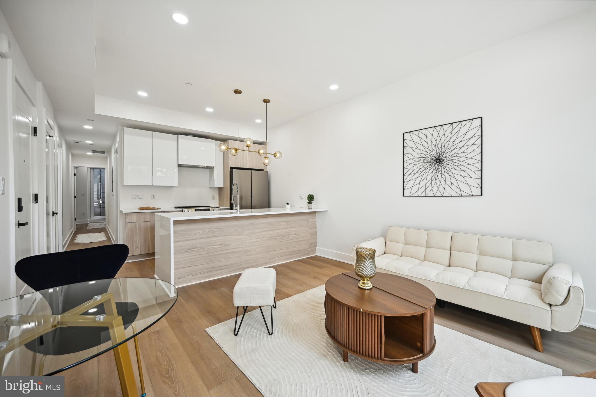 a living room with furniture and a view of kitchen