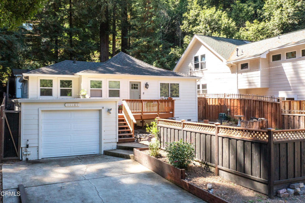 a view of a house with a small yard and wooden fence