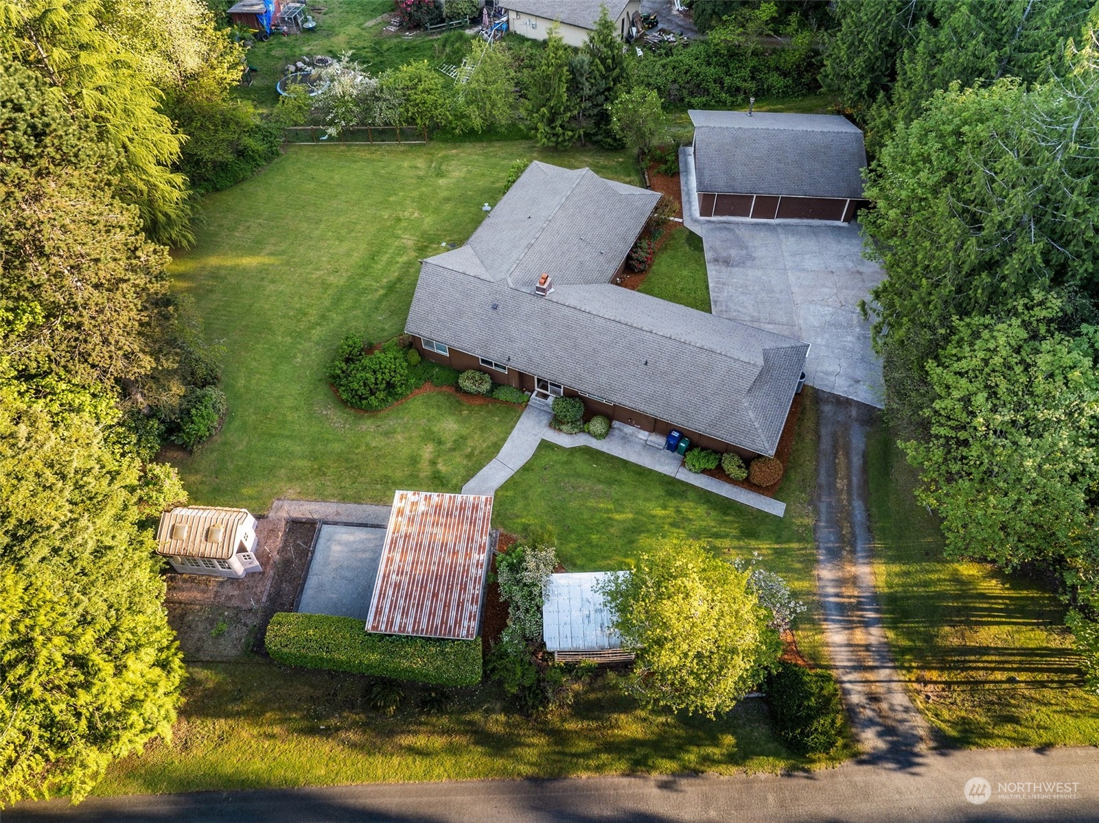 an aerial view of a house with swimming pool a patio and lake view