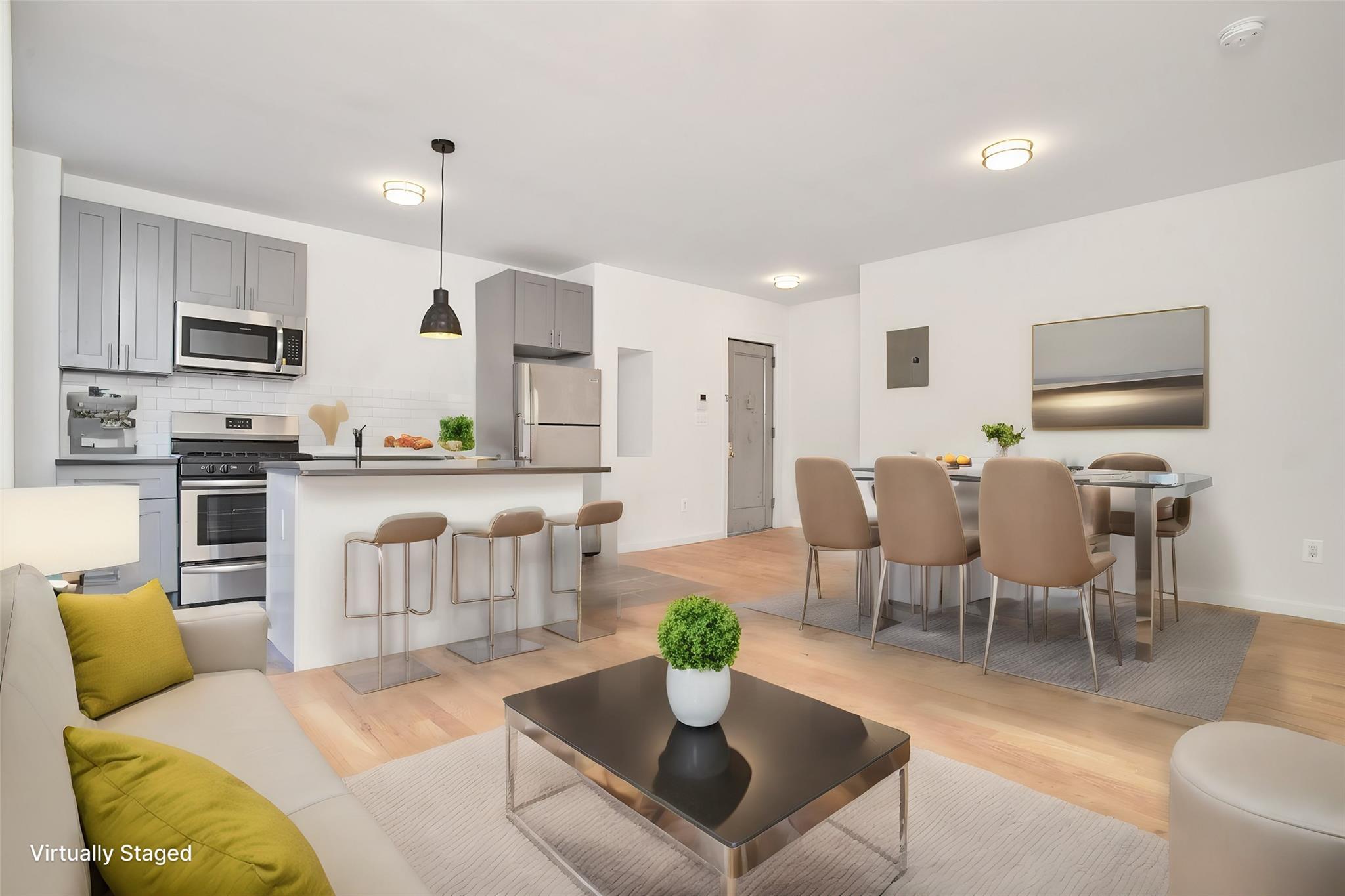 a living room with furniture kitchen view and a wooden floor