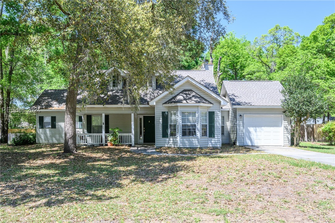 View of front of house featuring a porch and a gar