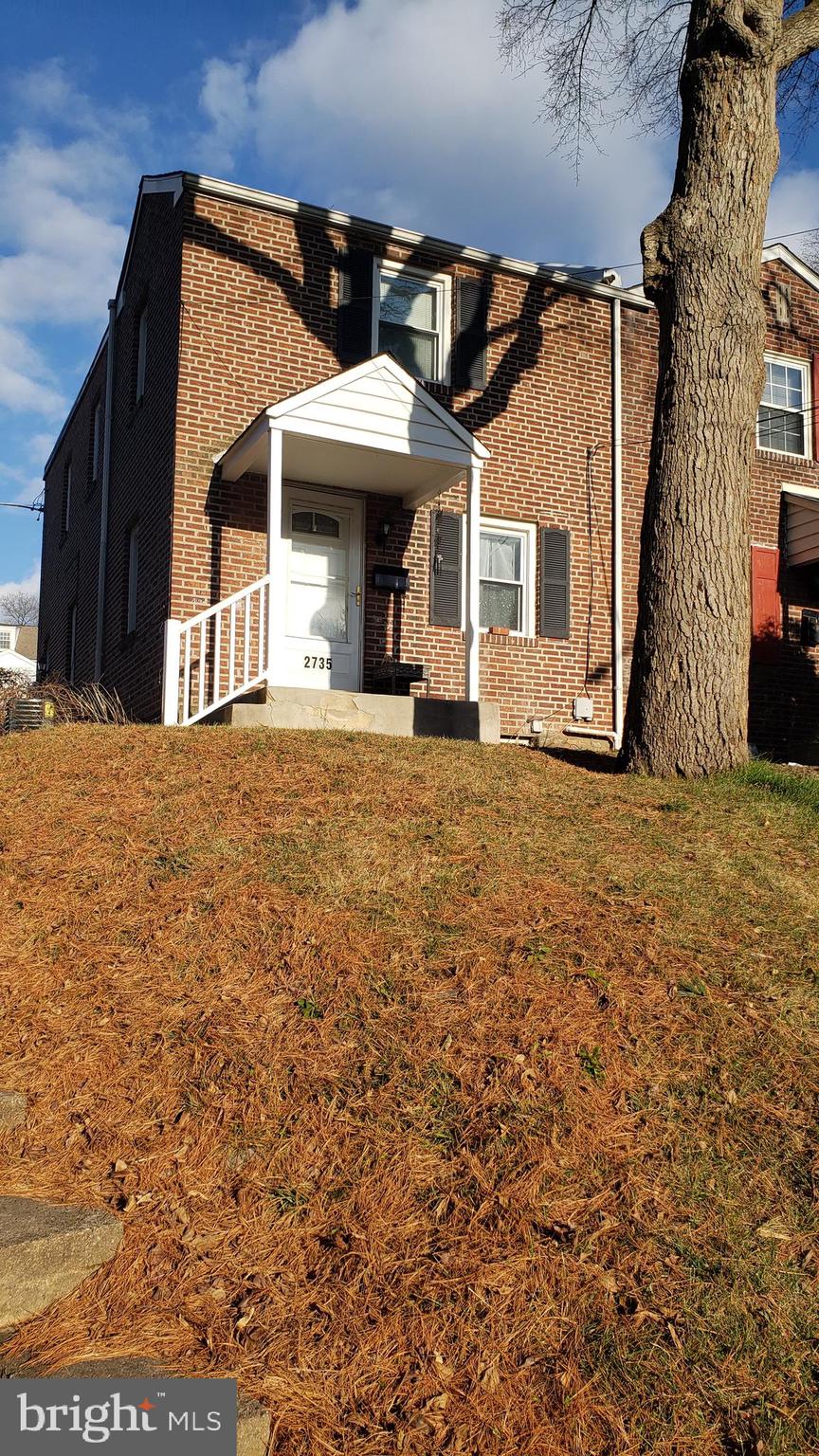 a view of a house with a big yard and large tree