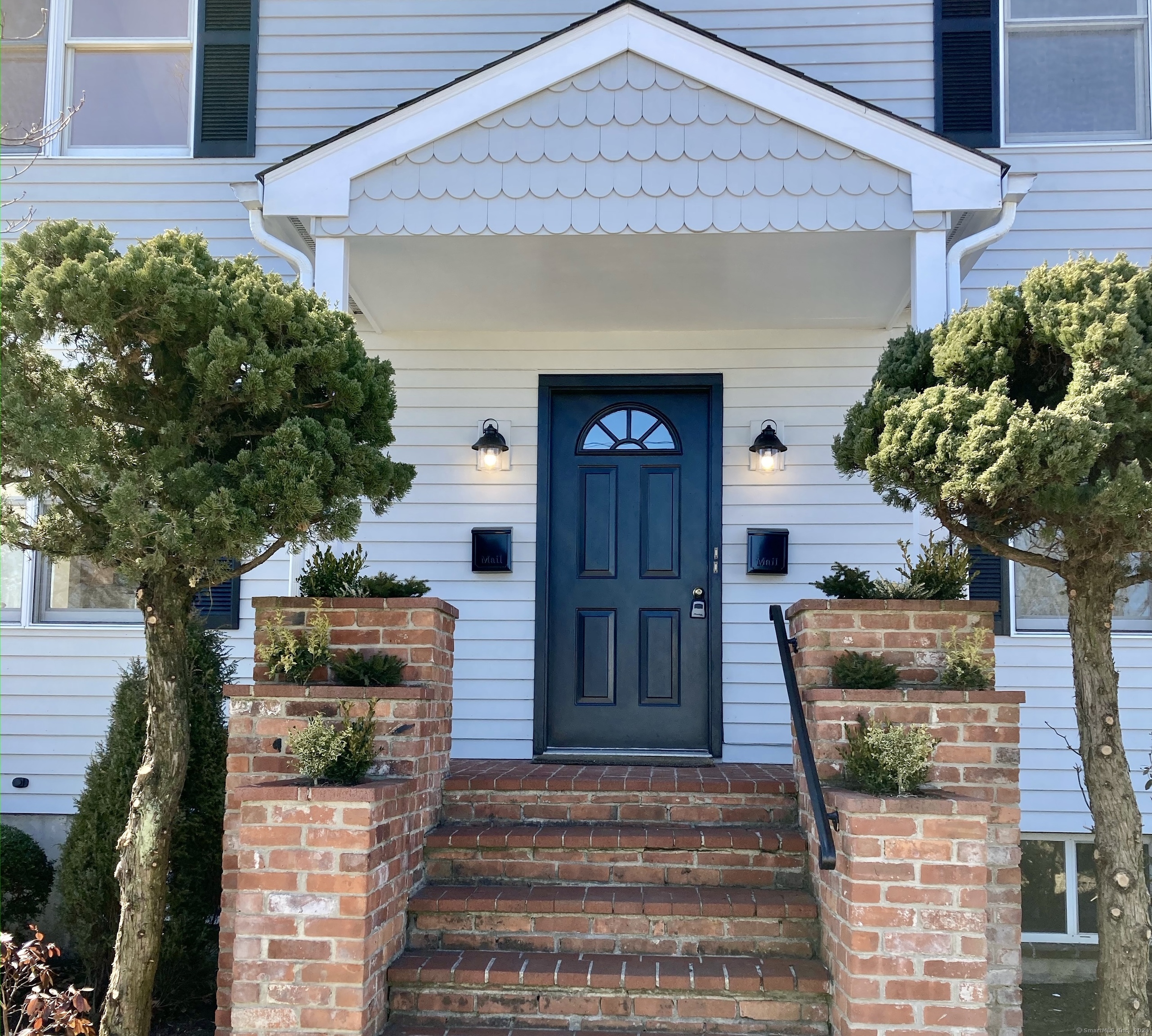 a front view of a house with potted plants