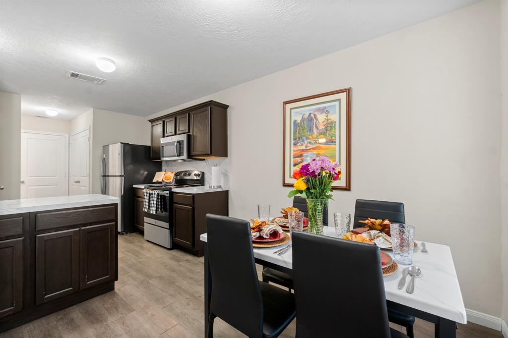 a kitchen with stainless steel appliances granite countertop a refrigerator and a stove top oven