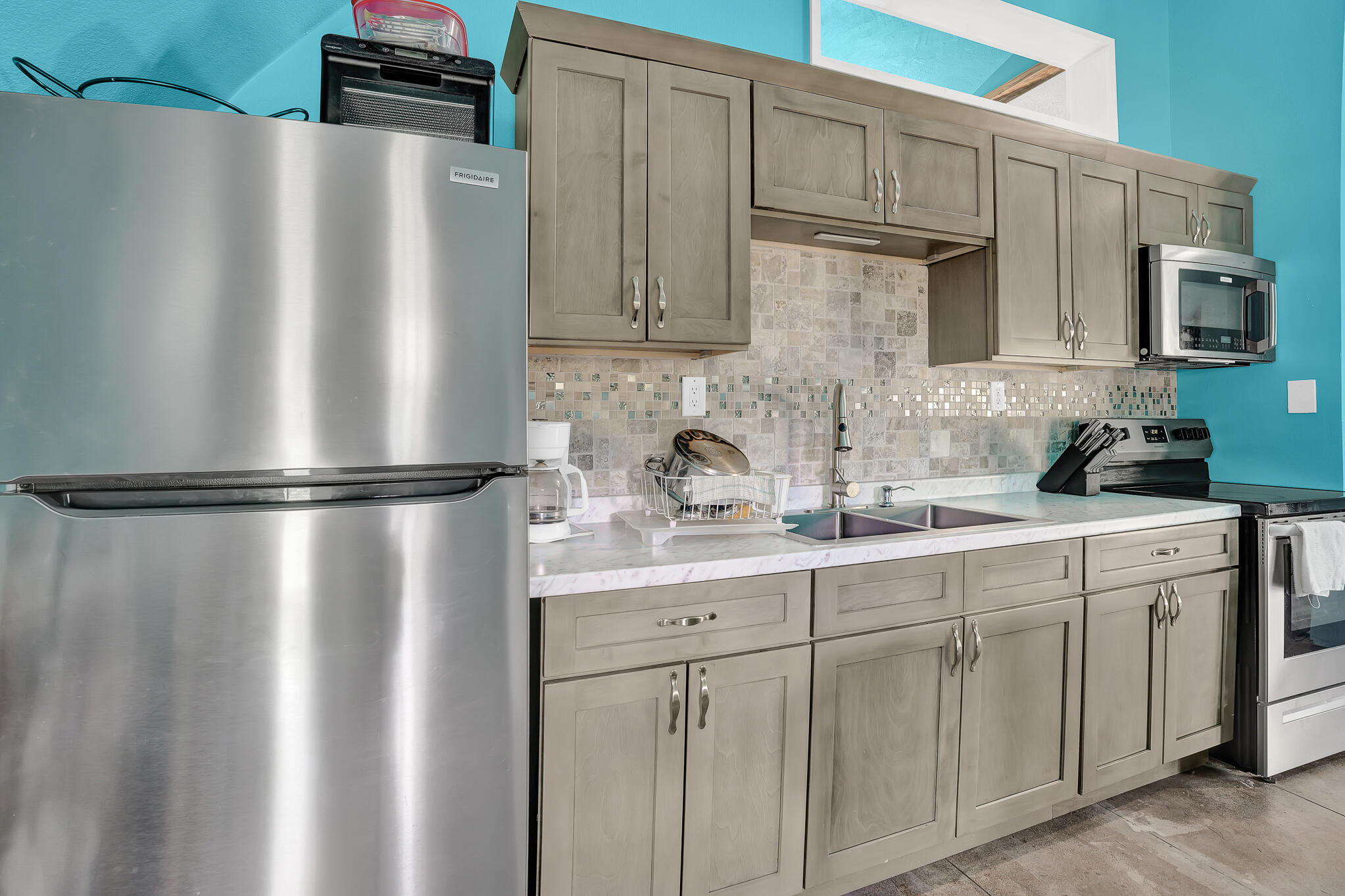 a kitchen with stainless steel appliances granite countertop a refrigerator a sink and white cabinets