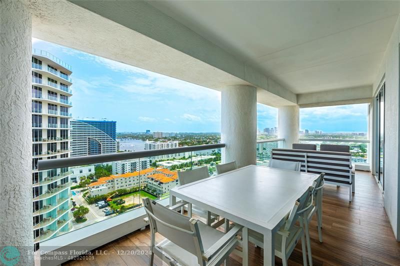 a balcony with furniture and wooden floor