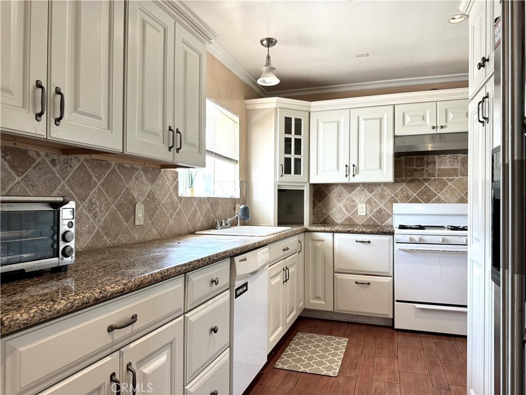 a kitchen with granite countertop white cabinets and white appliances