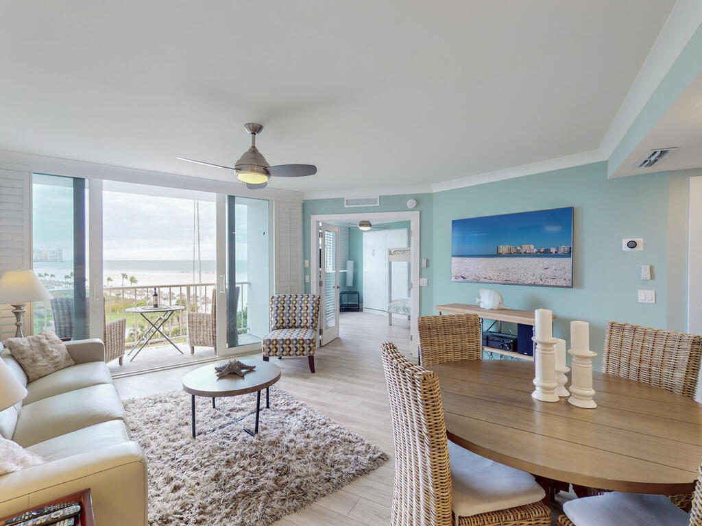 a living room with furniture a table and a large window