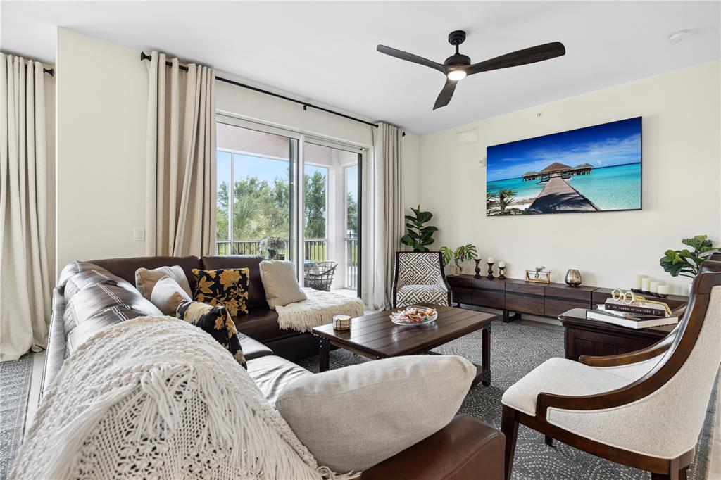 a living room with furniture a large window and a flat screen tv