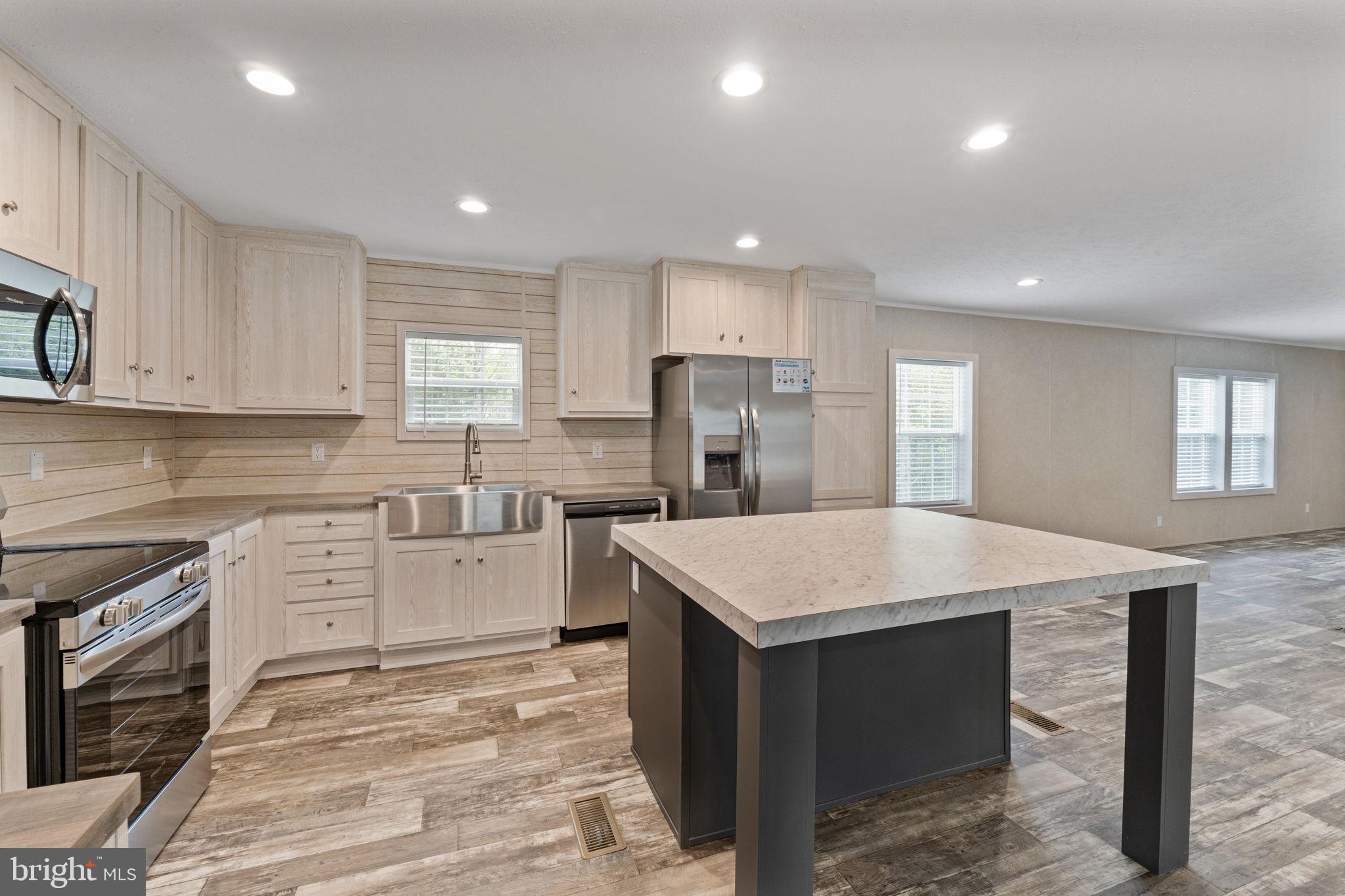 a kitchen with a stove sink cabinets and refrigerator