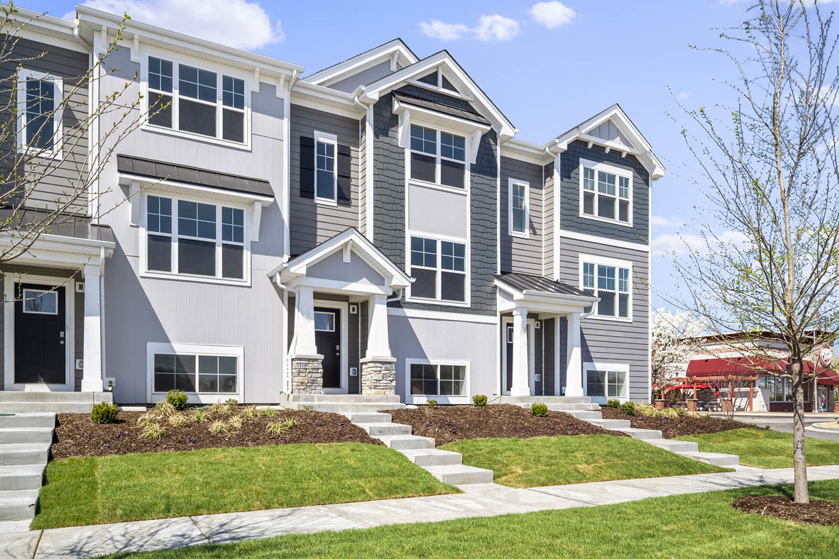 a front view of residential houses with yard and green space