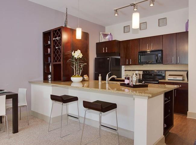 a kitchen with stainless steel appliances granite countertop a sink a stove a refrigerator and cabinets