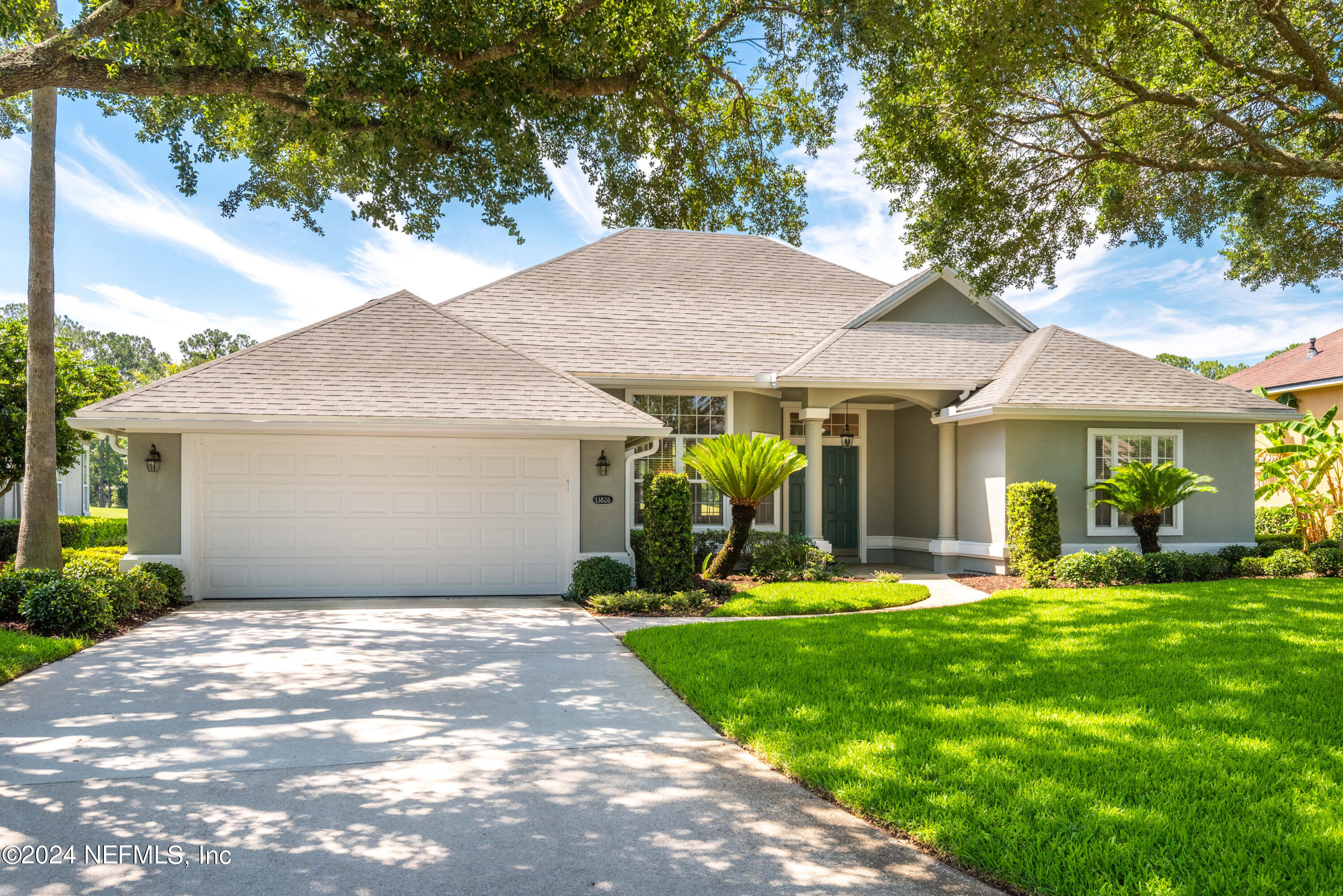 a front view of a house with a yard and trees