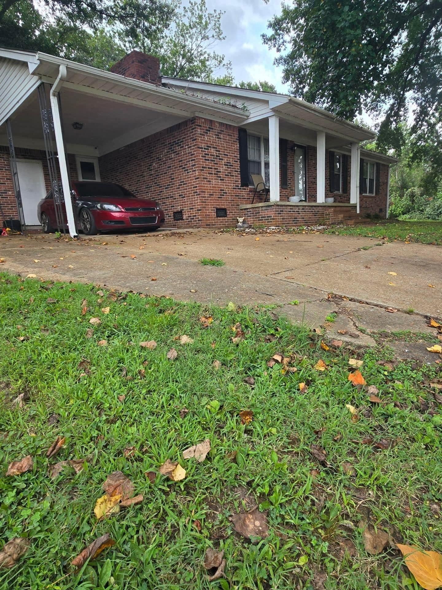 a view of a house with a patio and a yard