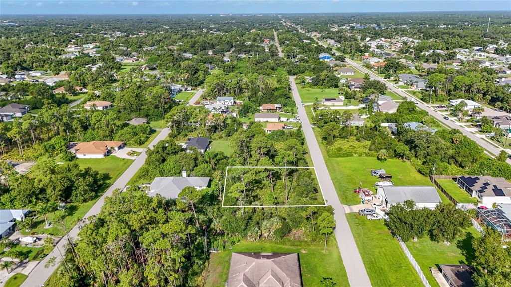 an aerial view of residential houses with outdoor space and trees