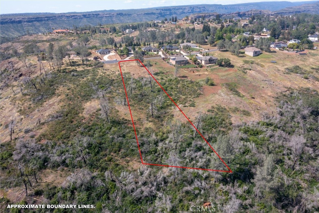 an aerial view of a houses with a yard and mountain