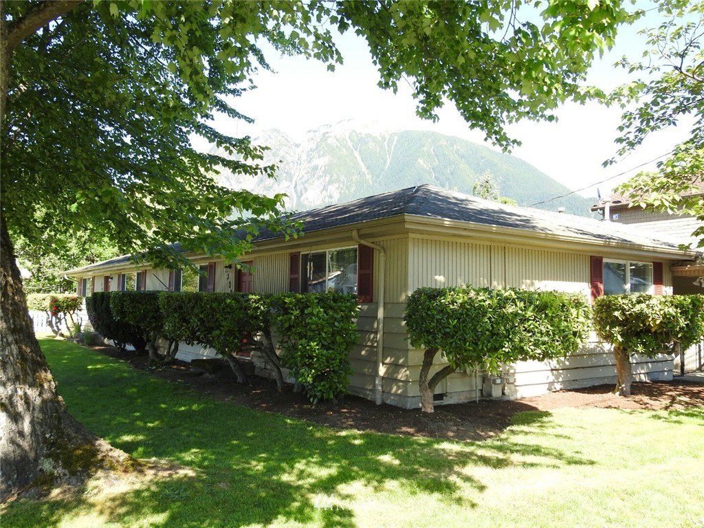 a front view of a house with a yard and potted plants